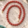 Collar de bolas de Coral manzana y detalles dorados